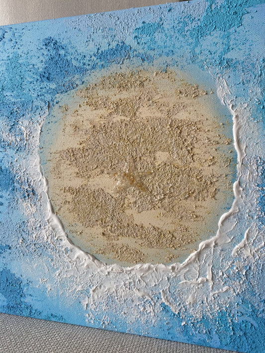 Close-up of the crystal starfish made with citrine and clear quartz embedded in sandy textured island.