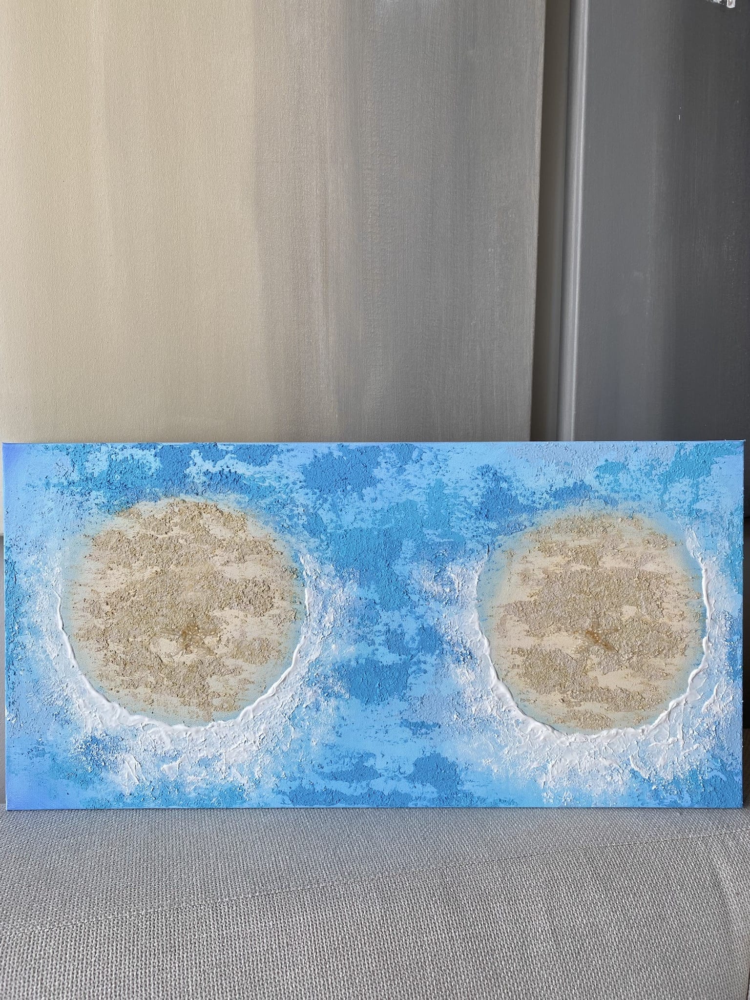 Original textured canvas artwork featuring two sandy islands surrounded by vibrant blue ocean waves, inspired by the feminine form.