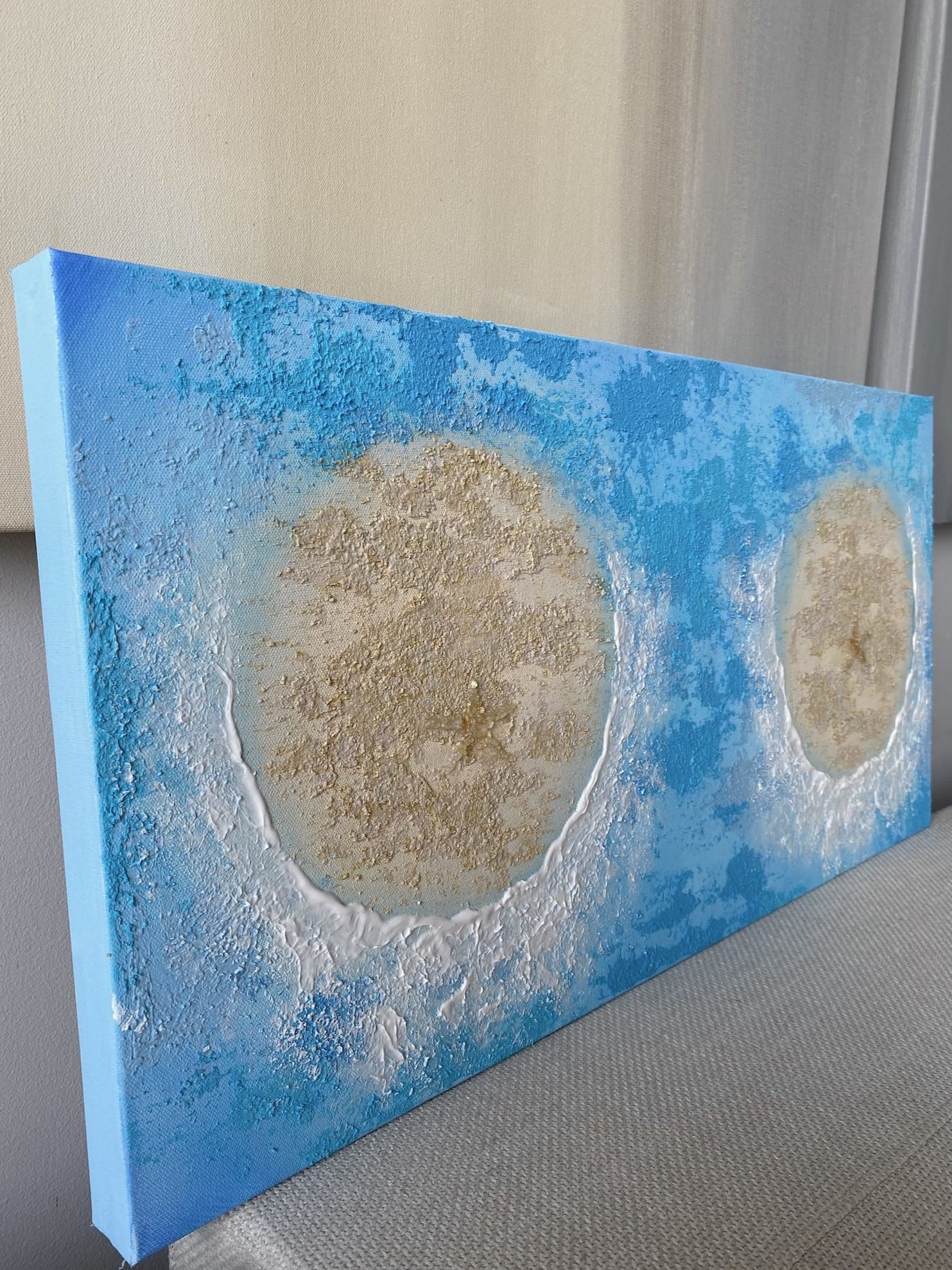 Side angle showing vivid ocean blue water, textured sandy islands, and white wave crests on canvas.